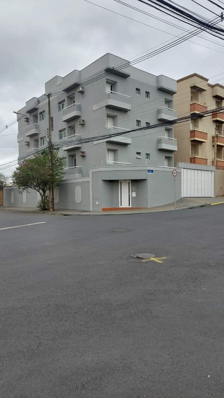 Prédio residencial cinza de quatro andares recém pintado em esquina