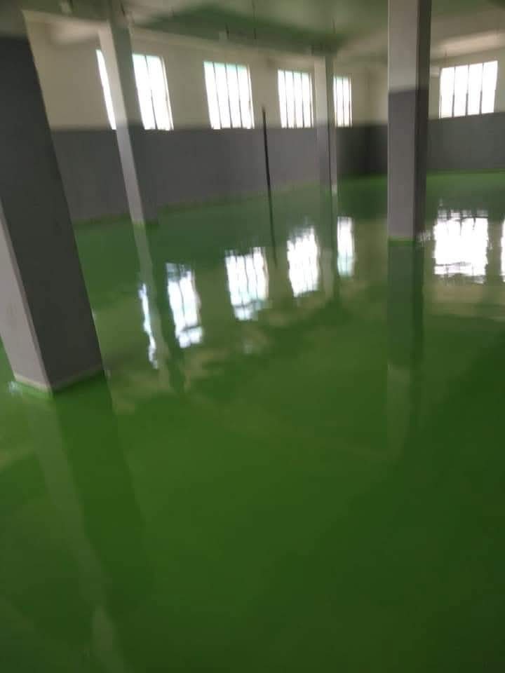Piso industrial verde brilhante em galpão com paredes bicolor